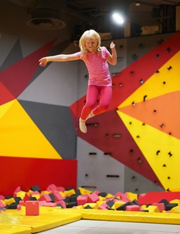 dziewczyna w różowym stroju wysoko skacze na trampolinach