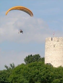 motoparalotnia na tle baszty w Kazimierzu Dolnym