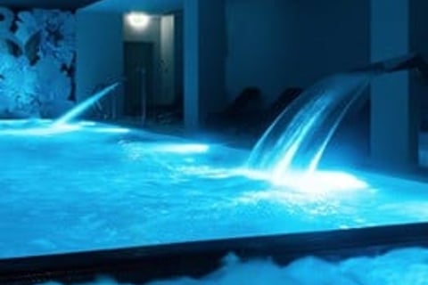 hotelowy basen z niebieskimi światłami i biczami wodnymi