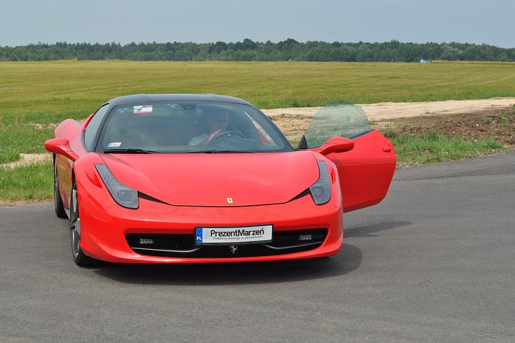 Sportowe Ferrari z uchylonymi drzwiami kierowcy