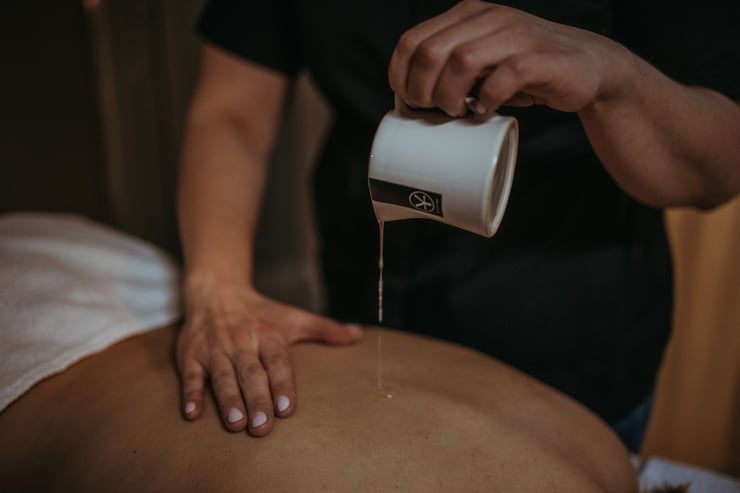 Wylewanie olejku do masażu na plecy