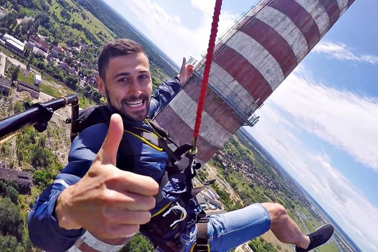 mężczyzna podczas skoku dream jump pokazuje kciuk w górę