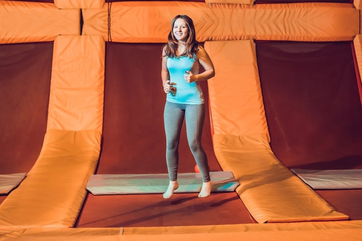 kobieta podskakuje na czerwonej trampolinie