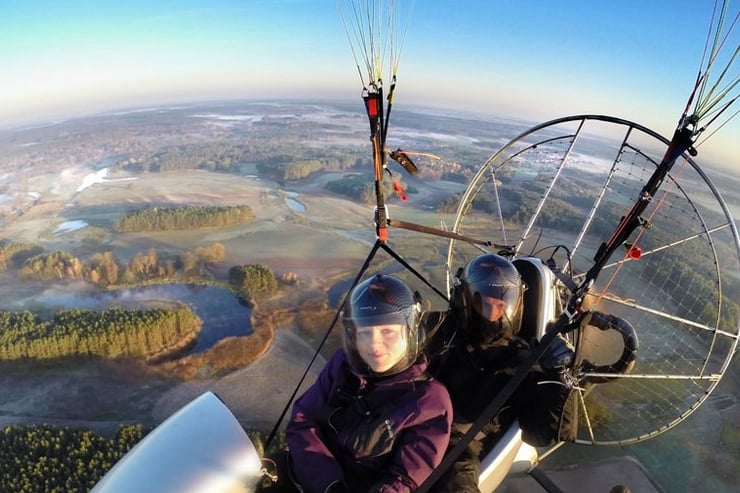 Lot motoparalotnią nad zamglonym krajobrazem