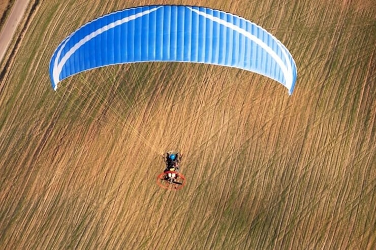 motoparalotnia lecąca nad polami