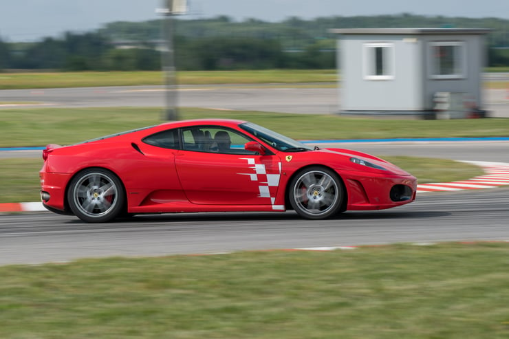 Widok na prawy bok Ferrari, na tle lasu