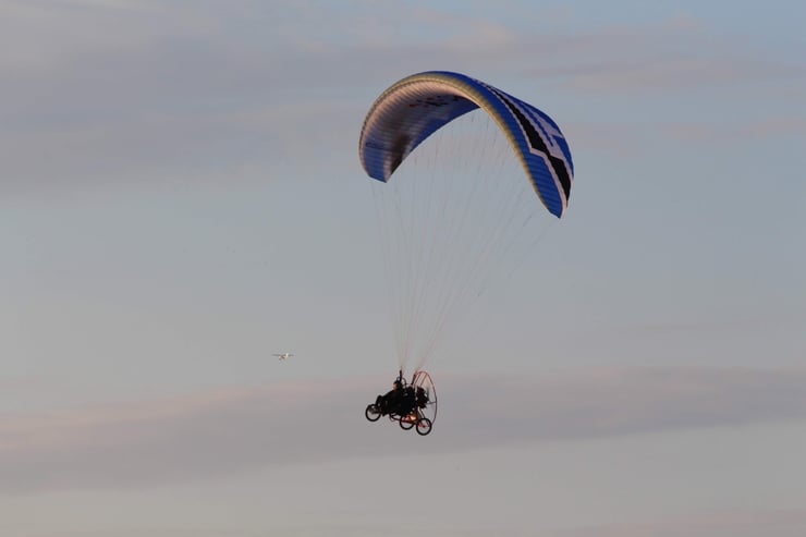 Lot motoparalotnią na tle błękitnego nieba